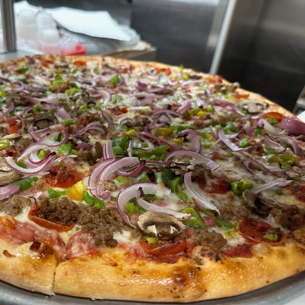 A large Eddies Pizza with pepperoni, sausage, mushrooms, green peppers, and red onions.